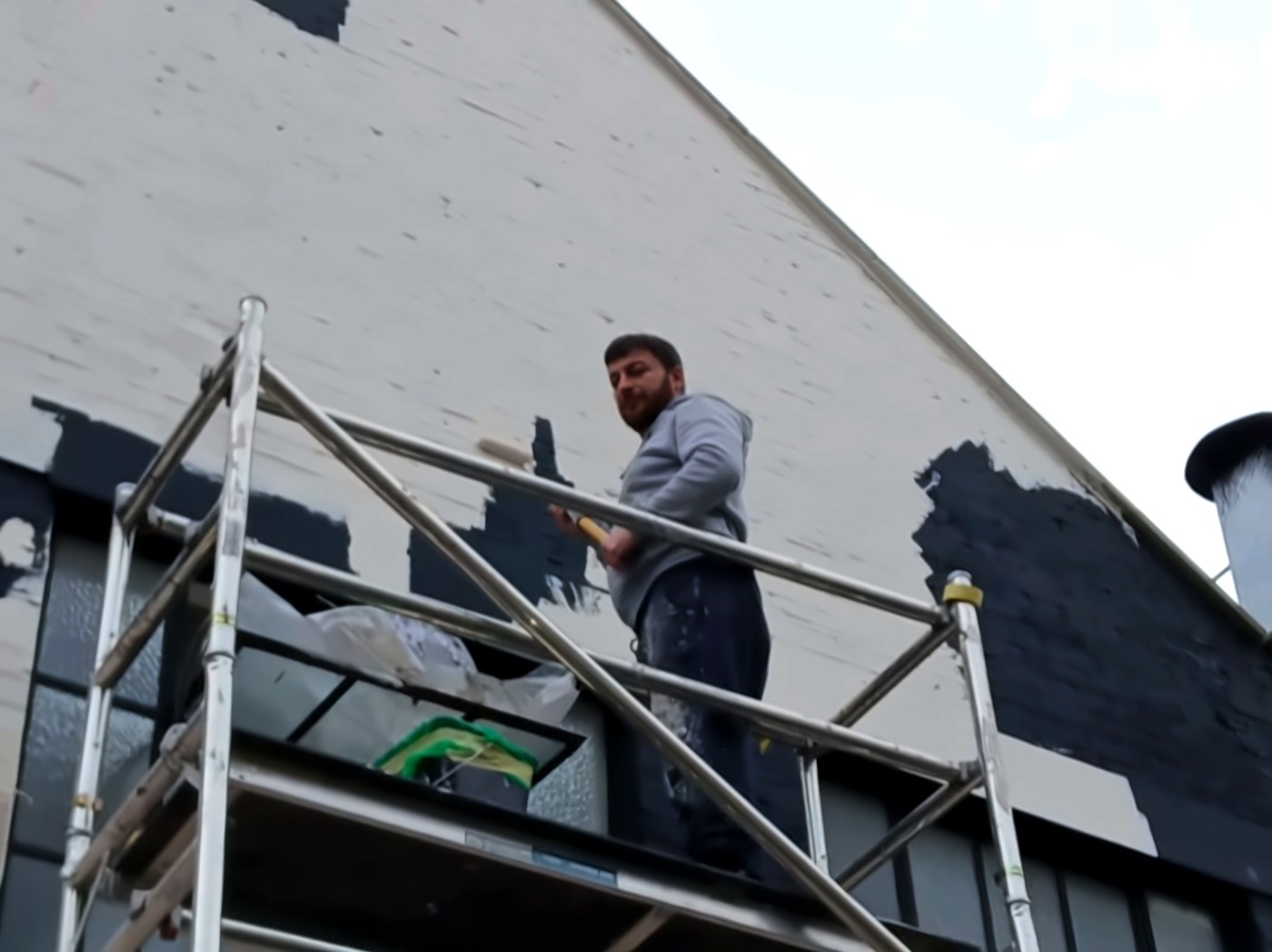 Zakro on a scaffold tower repainting a building gable